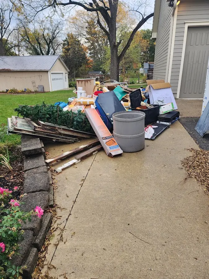 Dumpster being loaded with debris for Estate Cleanout Dumpster Rental in Belle Isle